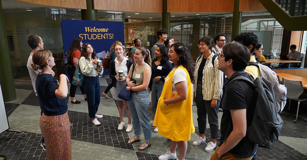 Students standing in the lobby of the school of public health, awaiting a building tour
