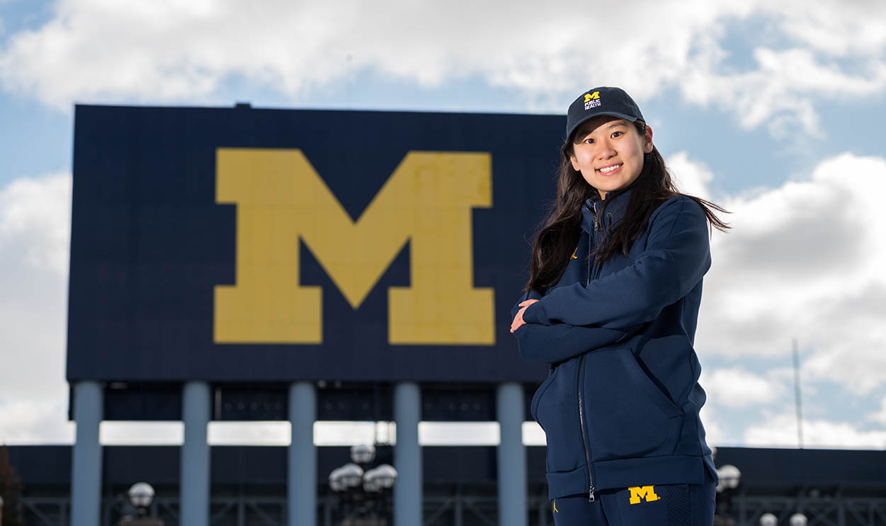 student in front of the big house