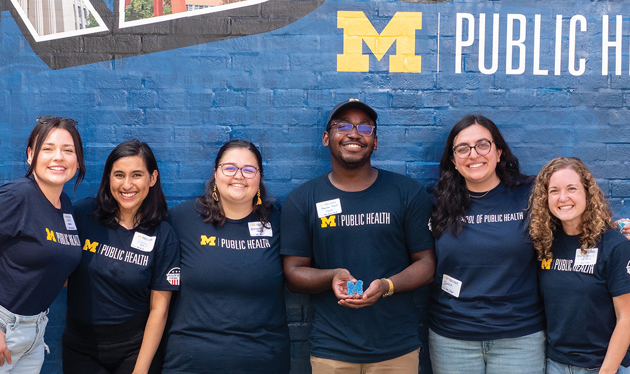 SPH students posing in front of a mural