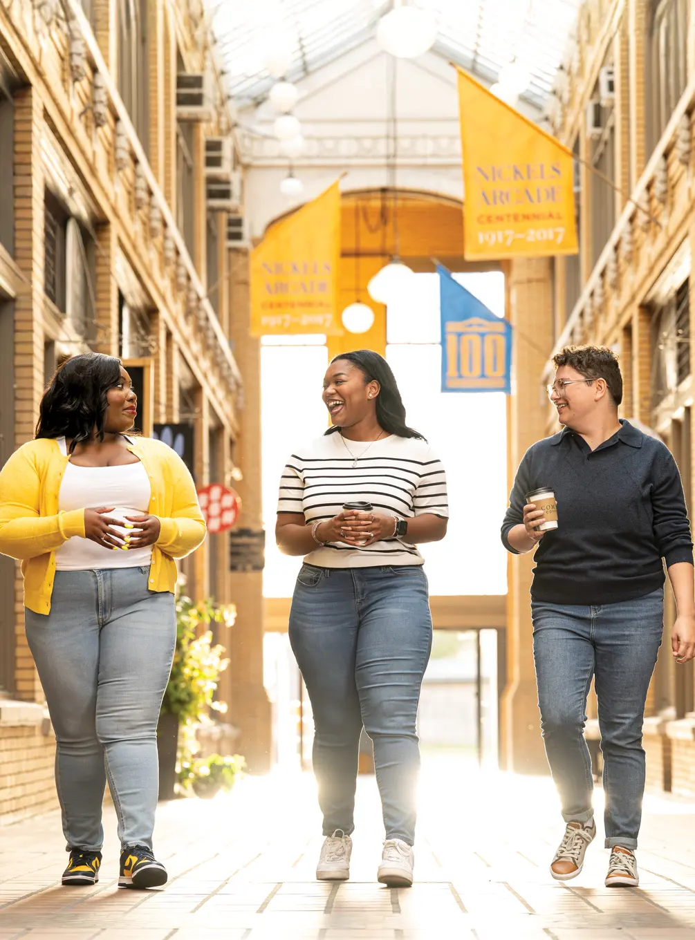 Jessica Holloway, center, walks with fellow School of Public Health students Cassandra Felix, left, and Geo Mifsud at the Nickels Arcade on the Ann Arbor campus.