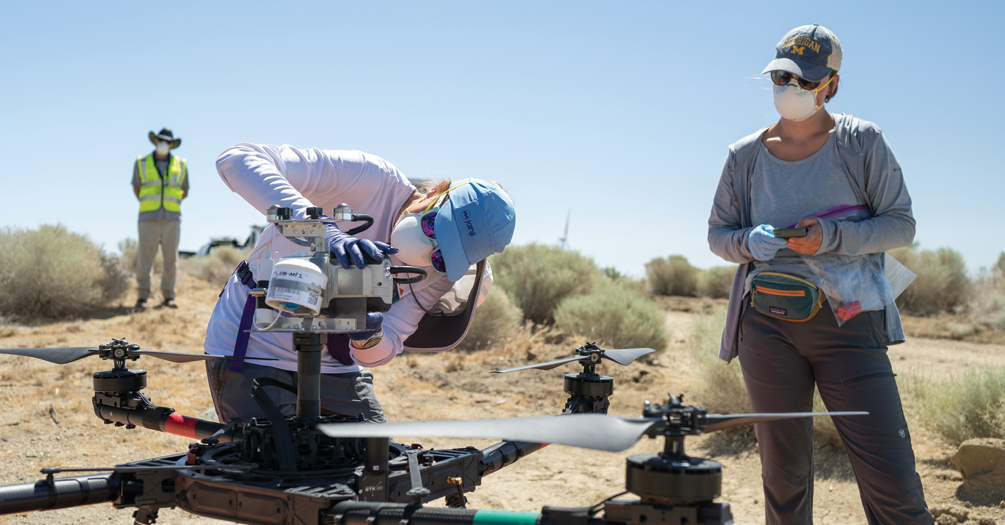 In Bakersfield, California, Jennifer Head, left, and student researcher Sarah Dobson load an air filter on a drone in order to sample air for the fungus that causes valley fever.
