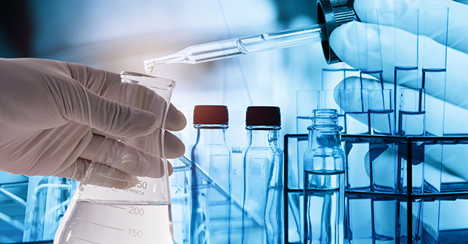 Gloved hands conducting an experiment in a lab setting.