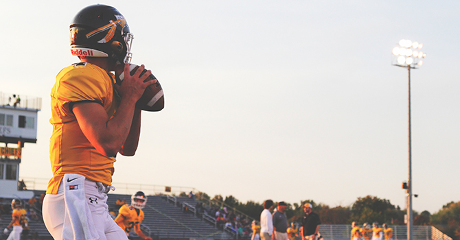 Football quarterback throwing a football.