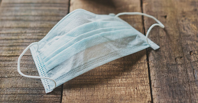 A blue mask on a wood table.