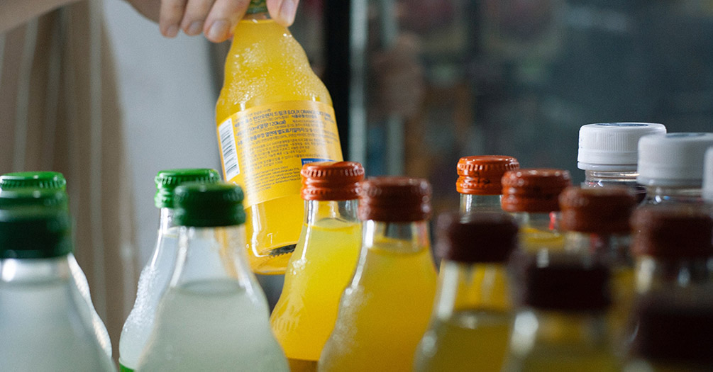 Multiple bottles of soda in a fridge