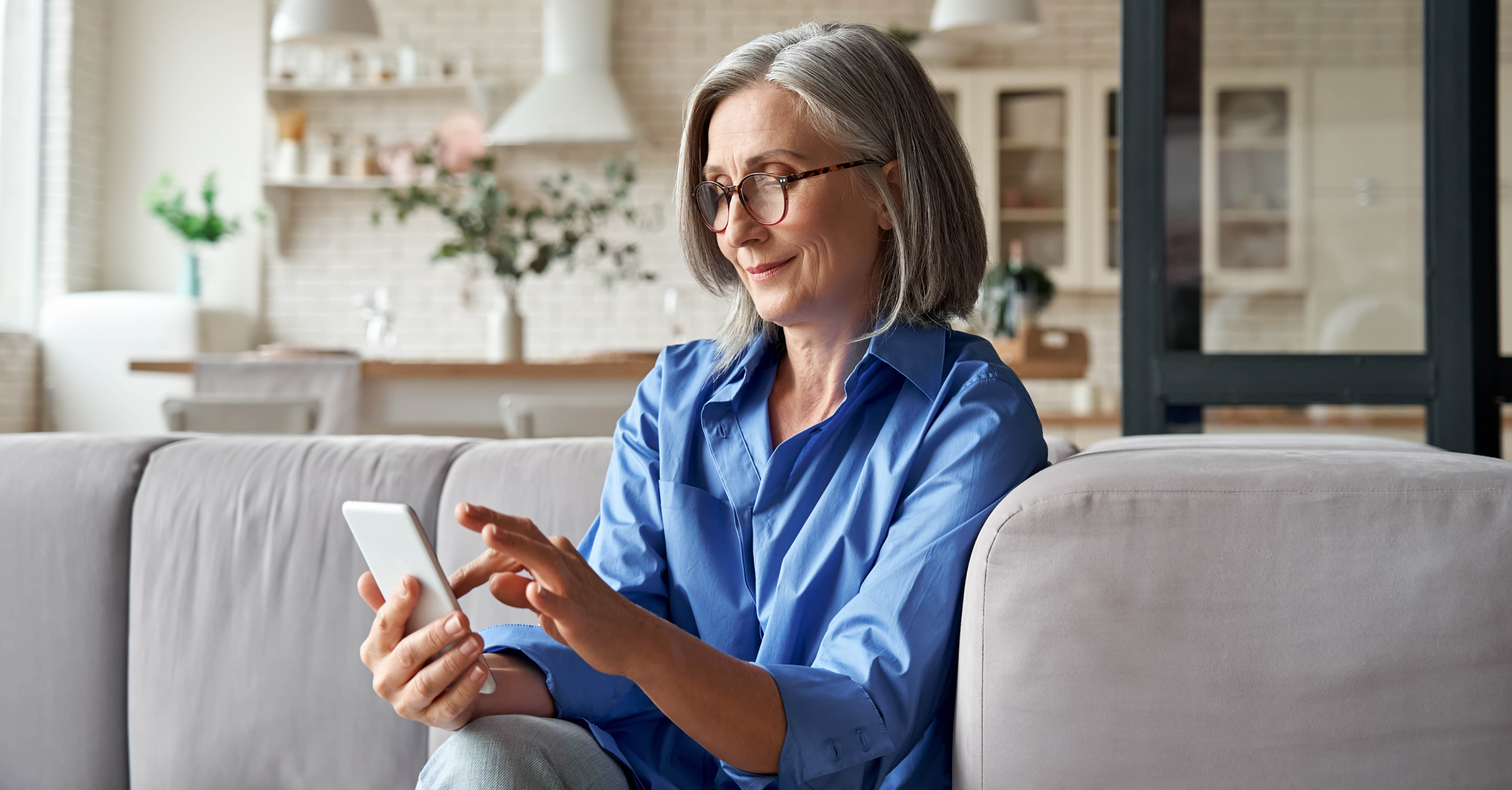 An older woman uses her phone to access a patient portal.