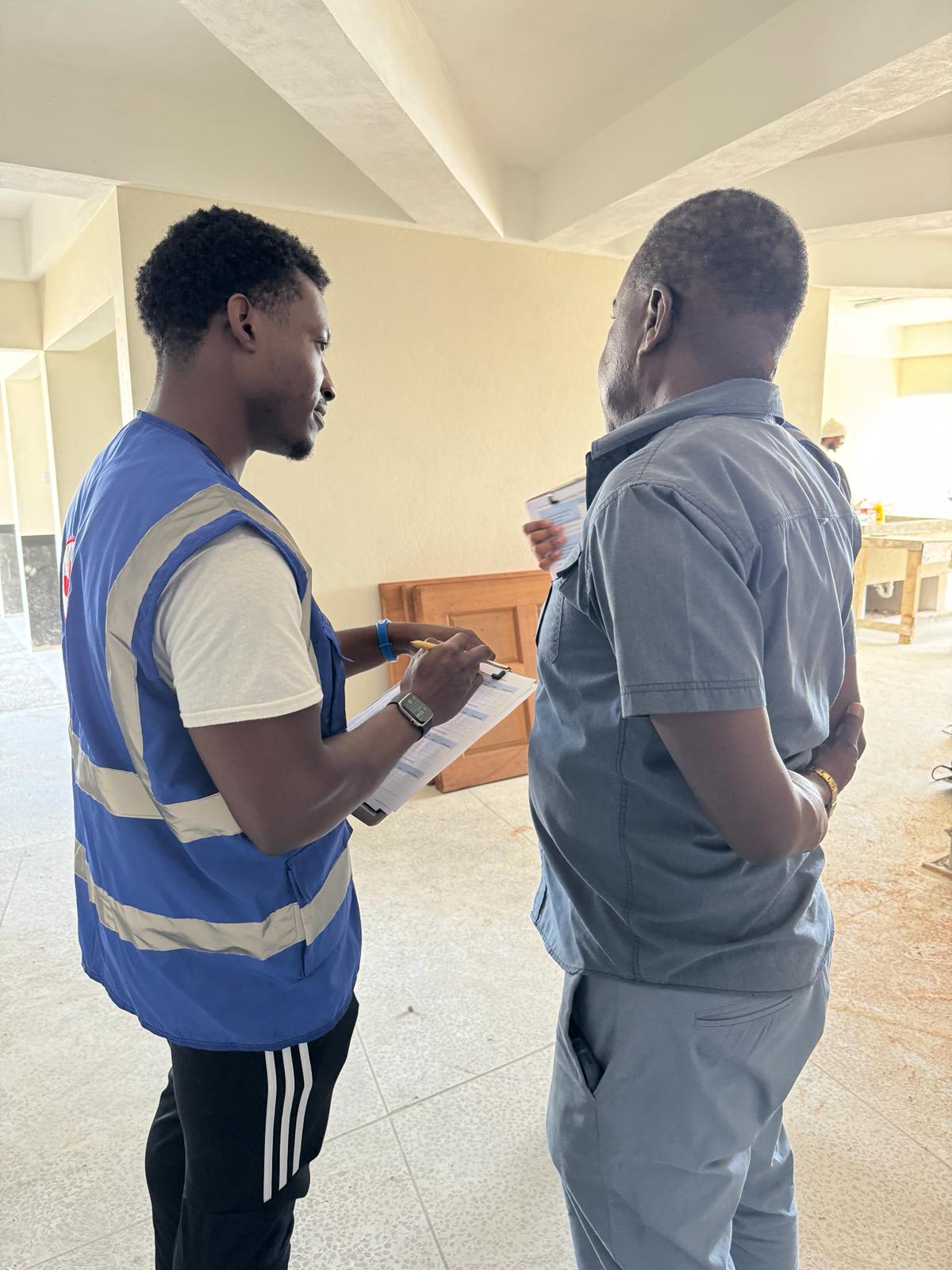 Caption: Darius Moore conducting a community survey with a local construction worker.