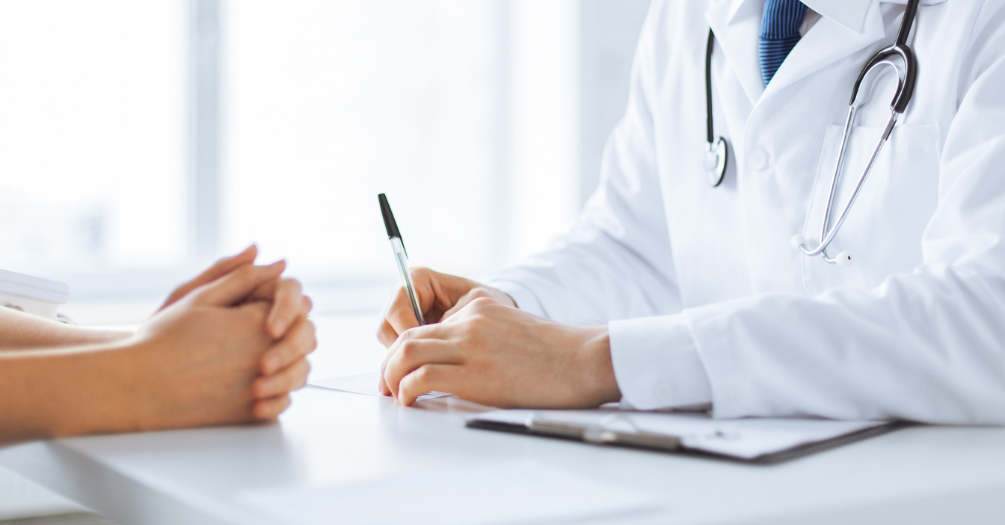 A doctor talks to a patient in their office.